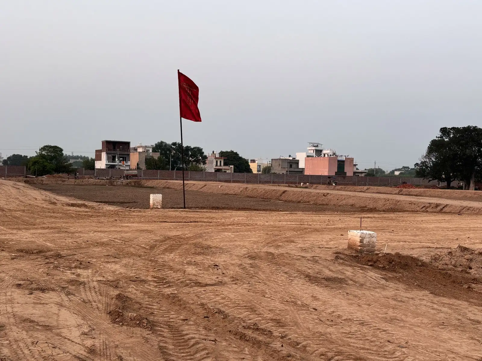 Residential plots marked with boundary pillars along an internal road at The Ridge, Kurali